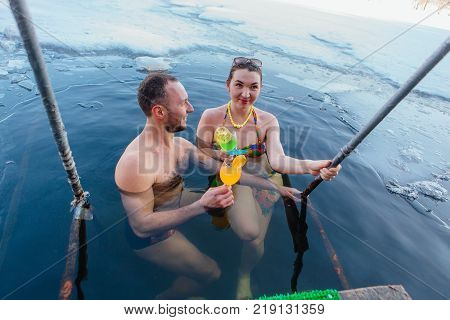 Novokuznetsk, Kemerovo region, Russia - 23 Feb, 2017 : White beaches of Siberia is an enterteiment activity where people playing beach games dressed in bikini in winter. Couple in ice hole