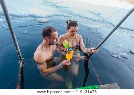 Novokuznetsk, Kemerovo region, Russia - 23 Feb, 2017 : White beaches of Siberia is an enterteiment activity where people playing beach games dressed in bikini in winter. Couple in ice hole