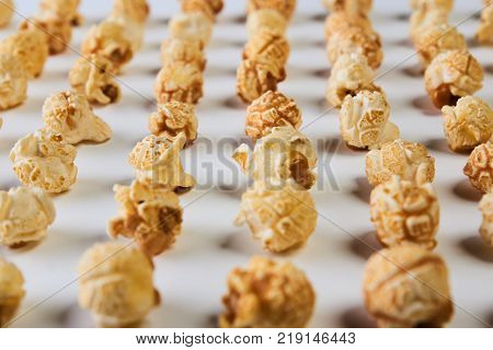 Popcorn isolated on white background. Pop corn kernel folded in the form of a corn beds, close-up. Farming and agriculture concept