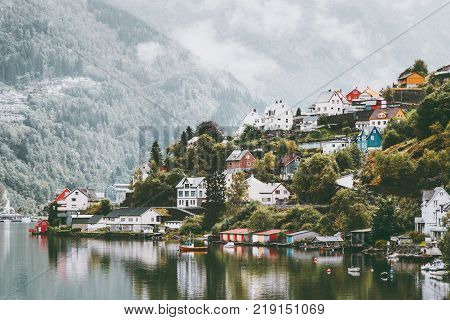 Odda city houses in Norway Landscape foggy mountains and water reflection