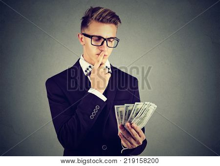 Ambitious young business man wearing glasses with money