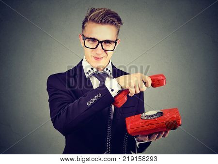 Annoyed sly business man hanging up telephone