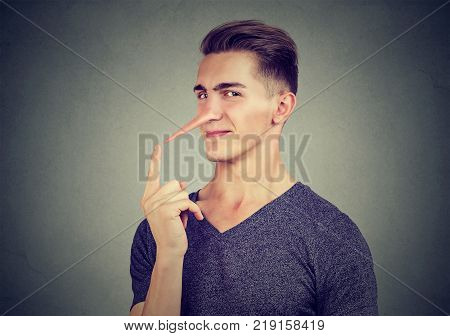 Man with long nose isolated on gray background. Liar concept. Human emotions feelings.