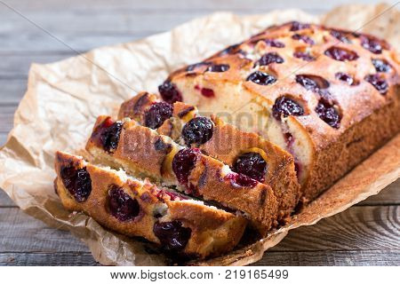 Pieces of cake with cherries on a wooden background