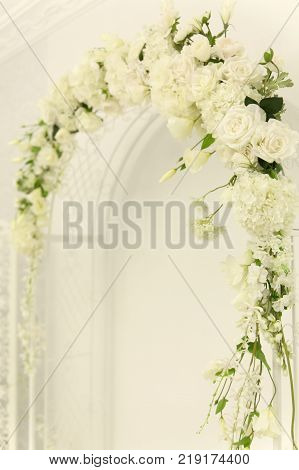 White wedding arch of flowers. Ceremony. Closeup