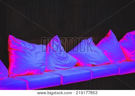 Pillows in Ultra Violet light a dark wall background. Color of the year 2018.