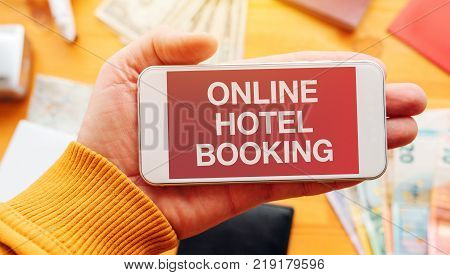 Online hotel booking app. Man holding smartphone with mock up appplication screen related to holiday vacation journey trip.