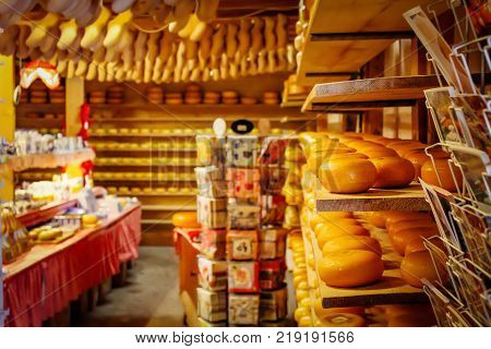 Souvenir shop in Netherlands with cheese and wooden shoes on the shelves. Tradition Holland klompen and clogs
