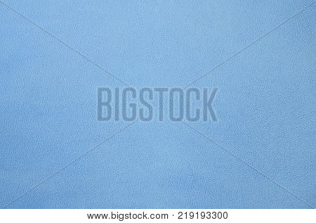 The blanket of furry blue fleece fabric. A background texture of light blue soft plush fleece material