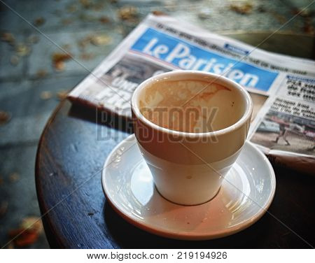 Paris France - September 9 2017: An empty coffee cup and Le Parisien newspaper on the cafe table.