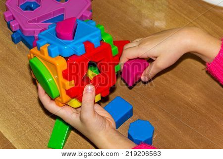 Closeup Of Child's Hand Taking Bright Mosaic Parts. Learning Colors At Home. Toddler Boy In A Stripe