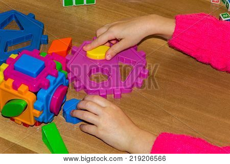 Closeup Of Child's Hand Taking Bright Mosaic Parts. Learning Colors At Home. Toddler Boy In A Stripe