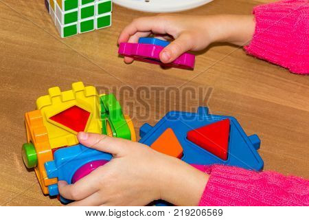 Closeup Of Child's Hand Taking Bright Mosaic Parts. Learning Colors At Home. Toddler Boy In A Stripe
