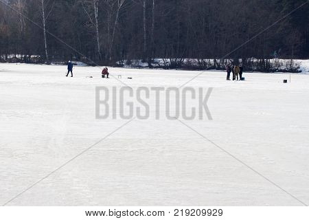 Winter fishing. River, lake near forest in ice. Anglers, Fishermens during your favorite leisure time. With place for your text, for background use