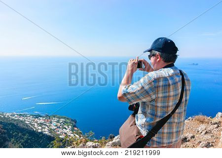 Man taking photos of beautiful scenery at Path of Gods in Tyrrhenian sea Amalfi coast Italy