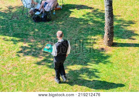 Waiter at Open air street restaurant with umbrellas in Ravello village Tyrrhenian sea Amalfi coast Italy