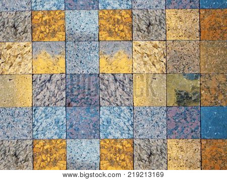 Checked pattern of various kinds of natural stone. A fragment of faced wall. Squares of grey, blue and gold for natural background.