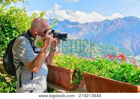 Ravello Italy - October 2 2017: Man taking photos with camera at the terrace in Ravello village Tyrrhenian sea Amalfi coast Italy autumn