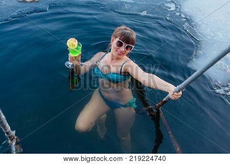 Novokuznetsk, Kemerovo region, Russia - 23 Feb, 2017 : White beaches of Siberia is an enterteiment activity where people playing beach games dressed in bikini in winter. Woman in an ice hole