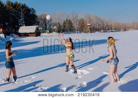 Novokuznetsk, Kemerovo region, Russia-23 Feb, 2017: White beaches of Siberia is an enterteiment activity where people playing beach games dressed in bikini in winter. Women playing volleyball on snow