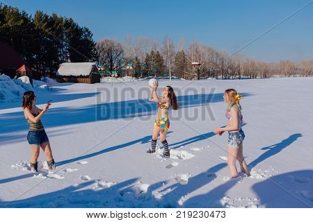 Novokuznetsk, Kemerovo region, Russia-23 Feb, 2017: White beaches of Siberia is an enterteiment activity where people playing beach games dressed in bikini in winter. Women playing volleyball on snow