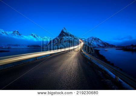Olstind Mount and car light. Lofoten islands, spring time, Norway