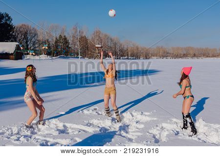 Novokuznetsk, Kemerovo region, Russia-23 Feb, 2017: White beaches of Siberia is an enterteiment activity where people playing beach games dressed in bikini in winter. Women playing volleyball on snow
