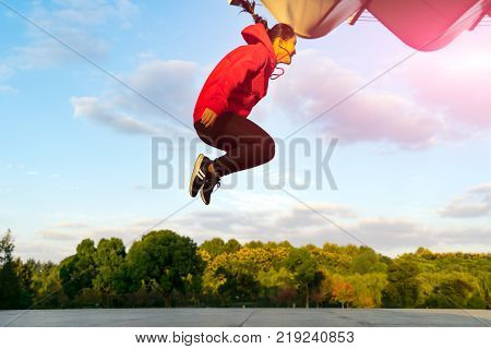 happy young woman is jumping over the garden - applier sunbeam
