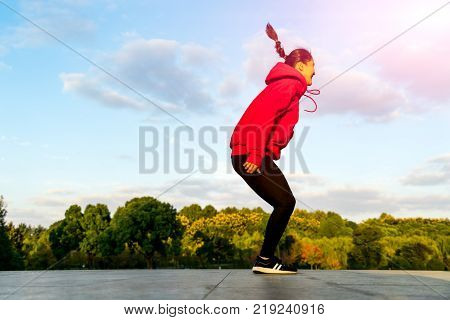 happy young woman is jumping over the garden - applier sunbeam
