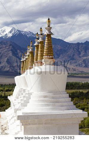 Buddhist chortens white stupa and Himalayas mountains in the background near Shey Palace in Leh in Ladakh Jammu and Kashmir India