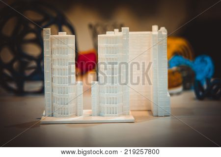 Abstract object of a white green color printed on a 3d printer on a white table. Fused deposition modeling, FDM. Progressive modern additive technology. Concept of 4.0 industrial revolution