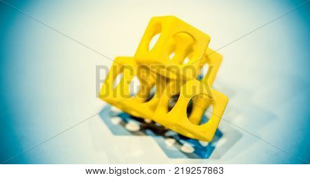 Abstract object of a yellow color printed on a 3d printer on a white table. Fused deposition modeling, FDM. Progressive modern additive technology. Concept of 4.0 industrial revolution