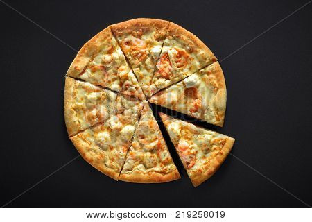 pizza with shrimps tomato cheese on a black stone background