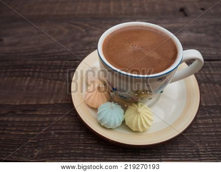 Freshly brewed cocoa and colorful bee on an old wooden table