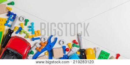 Kids toys banner background. Toy tools, bolts, nuts, car, construction blocks, cubes on white background.