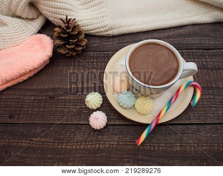 Freshly brewed cocoa and colorful biseza with candy on an old wooden table