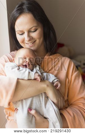 a young mother enjoys the first days of motherhood with her child holding it in her arms