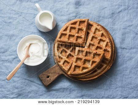 Whole wheat breakfast viennese waffles cream and milk on blue background top view