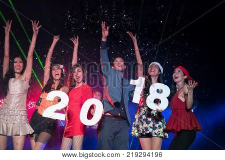 Group of funny friends company in luxury outfits with xmas headwear.Holding 2018 number latter.Amazed cheerful people laughing at the club at new year. Entertain and night life mode concept.