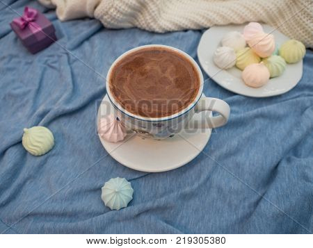 Freshly brewed cocoa with foam and colorful bise on the table