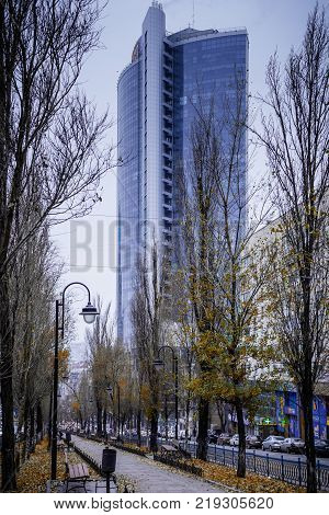 Tall blue building behind autumn boulevard in Kiev