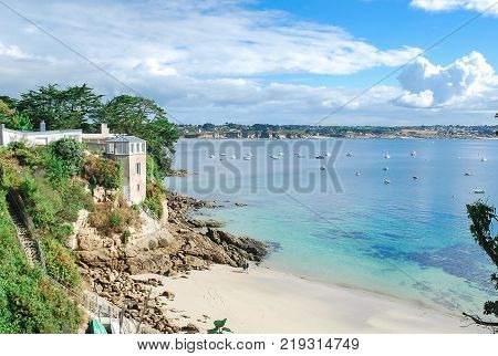 Beautiful seascape with a house of seaside white sand blue aqua transparent of the sea some boat float on sea with white clouds and blue sky seaside in France Europe.