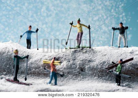 some different miniature skiers in a snowy landscape on winter time