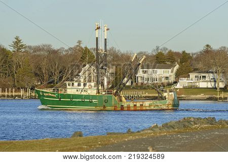 New Bedford Massachusetts USA - December 21 2017: Fishing vessel Ilha Brava on the Acushnet River with Fairhaven in background