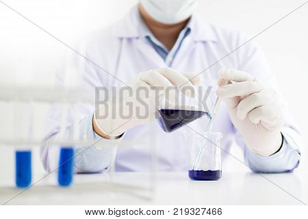 scientists and scientific equipment Pouring mixing reagents liqiud beakerLaboratory research chemistry concept