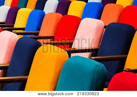 The auditorium in the theater. Multicolored spectator chairs.