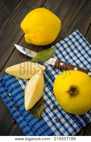 Sliced yellow quince or queen apple fruits with seeds on blue checkered towel top view