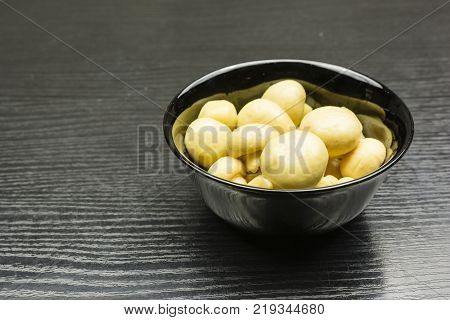 Bowl with marinated mushrooms (Agaricus) on the table.