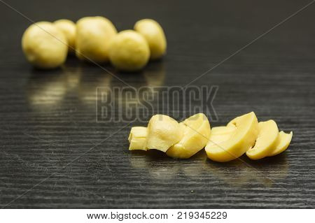 Sliced marinated mushroom (Agaricus) on a wooden dark table.