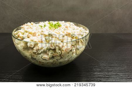Bowl with vegetable salad on a wooden table.